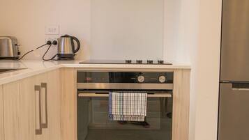 A kitchen with wooden cabinets, a stainless steel oven, and a built-in refrigerator.