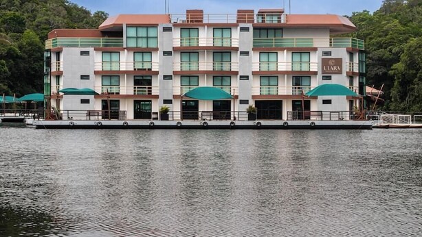 Et hotel med flere etager, flad tag, store vinduer og en dock, der strækker sig ud i vandet.