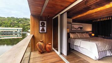Une chambre avec un grand lit, une vue sur un lac et un plancher en bois.