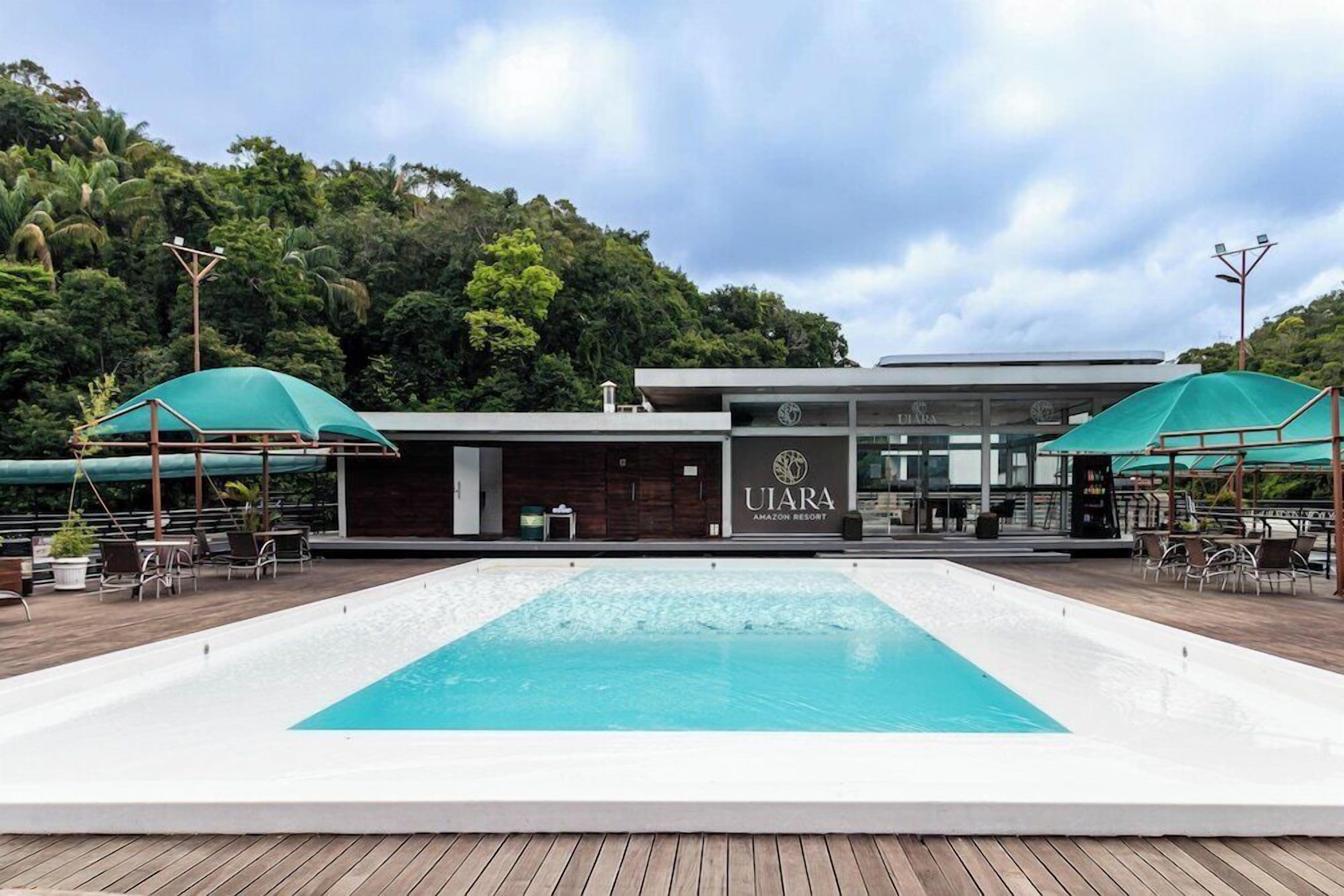 A swimming pool with a building labeled 'UIARA AMAZON RESORT' in the background.
