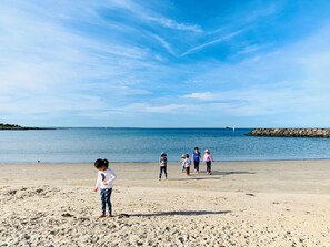 A sandy beach with a clear sky and calm sea.