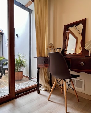 A room with a desk, chair, mirror, lamp, and a potted plant. - Colonial Courtyard Suite in Centro Histórico + Tranvía Tram (Cuenca)