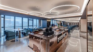A modern hotel lobby with a central bar, seating areas, and large windows offering city views. - Crystal Orange Shenzhen Bao'an Joy City (Shenzhen)