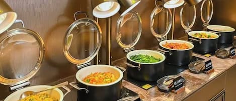 A buffet with various dishes, each in a separate pot with a lid, and a sign indicating the type of cuisine.