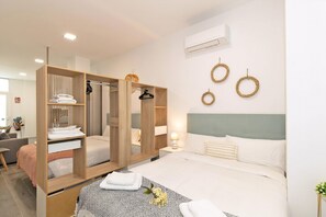 A modern hotel room with a bed, a wardrobe, a bedside table, and a mirror. - Guestready - Fontilles Apartments (Valencia)