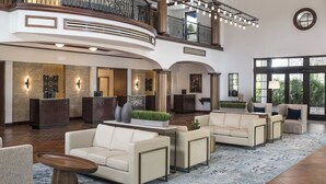 Eine geräumige Lobby mit Empfangsschalter, Sitzgelegenheiten und einem Balkon.