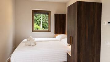 A bedroom with a bed, a window, and a wardrobe.