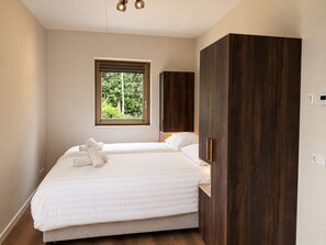 A bedroom with a bed, a window, and a wardrobe.