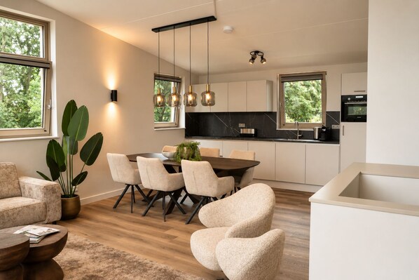 Una cucina moderna con zona pranzo, ampie finestre e una pianta in vaso.