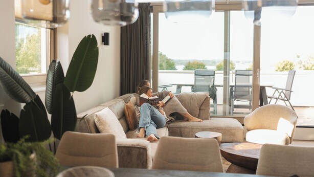 Un salon moderne comprenant un canapé, une table basse et un coin repas avec des chaises.