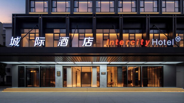 A modern hotel entrance with illuminated signage, large glass doors, and a clean, contemporary facade. - Intercity Hotel Futian Convention (Shenzhen)