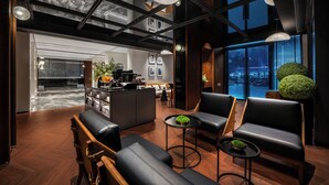 A modern interior with a dining area, seating, and a view of the city. - Intercity Hotel Futian Convention (Shenzhen)
