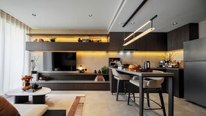 A modern kitchen with a central island, bar stools, a built-in oven, and a large refrigerator. - The Panora Estuaria Pattaya (Sattahip)