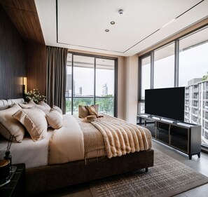 A modern bedroom with a large bed, a television, and a city view. - The Panora Estuaria Pattaya (Sattahip)