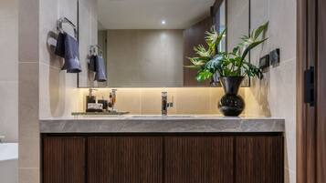 Un baño moderno con un espejo grande, un lavabo y un mueble de tocador de madera.
