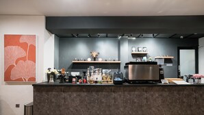 A modern bar area with a marble counter, a coffee machine, and various bar tools. - Dhipa Kinanthi Prawirotaman by Raminten (Yogyakarta)