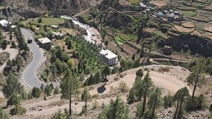 Des champs agricoles en terrasses, une route sinueuse et des bâtiments dispersés.