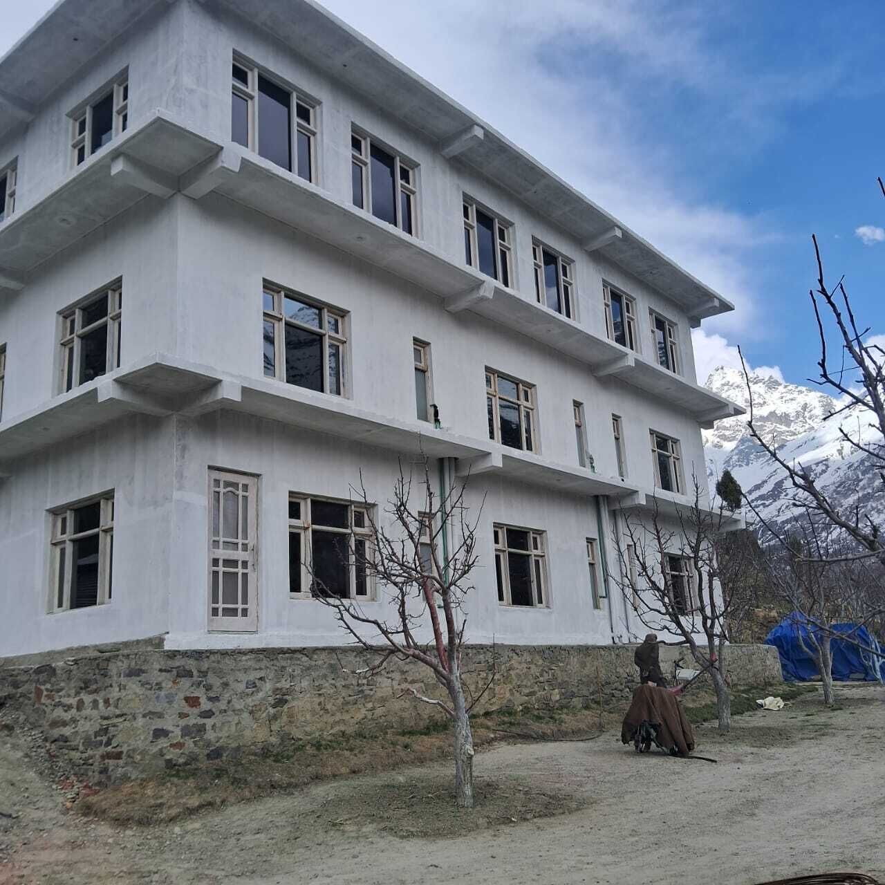 A multi-story building with a simple, modern architectural style, featuring a flat roof and large windows.