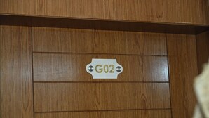 A wooden panel wall with a sign labeled 'G02'.