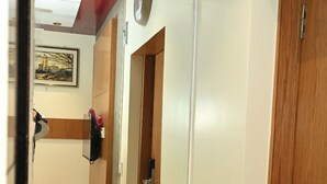 A bathroom with a white sink, a mirror, and a wooden door.