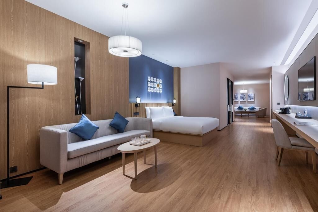 Et moderne hotelværelse med sofa, seng, skrivebord og sofabord.