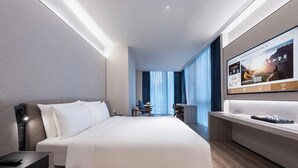 A modern hotel room with a large bed, a desk, and a TV screen. - Orange Crystal Nanshan Science Park (Shenzhen)