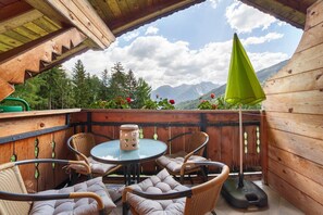 A wooden deck with wicker chairs and a table, overlooking a mountainous landscape. - Apartment 'A' with Mountain View, Balcony and Wi-Fi (Moso in Passiria)