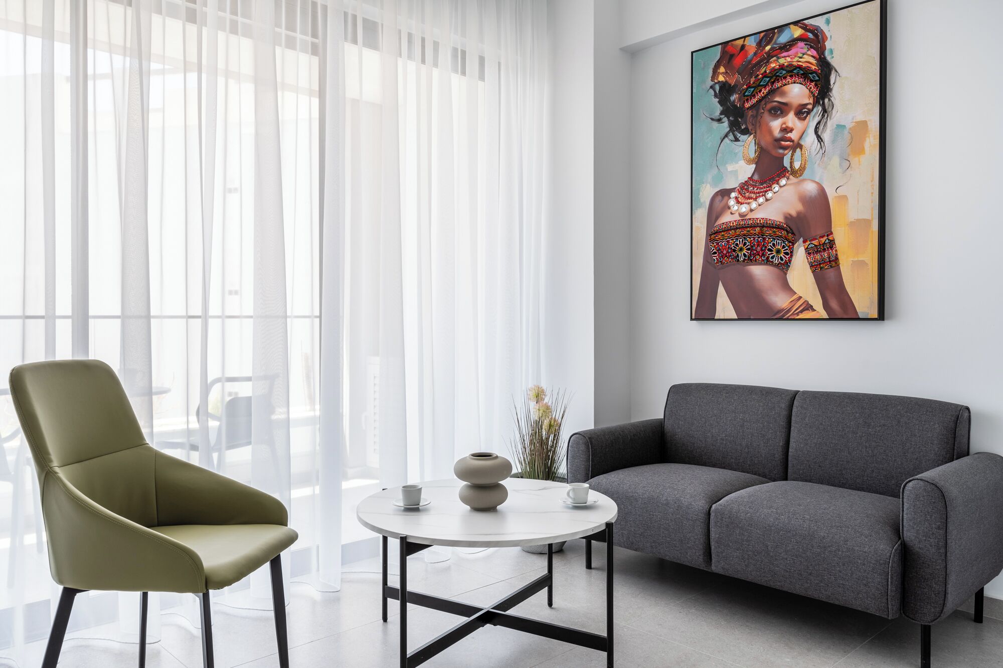 A modern living room with a sofa, a chair, a round table, and a large painting on the wall.