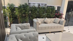 A modern living room with a sofa set, a coffee table, and a potted plant. - Krishneya Dham (Mathura)