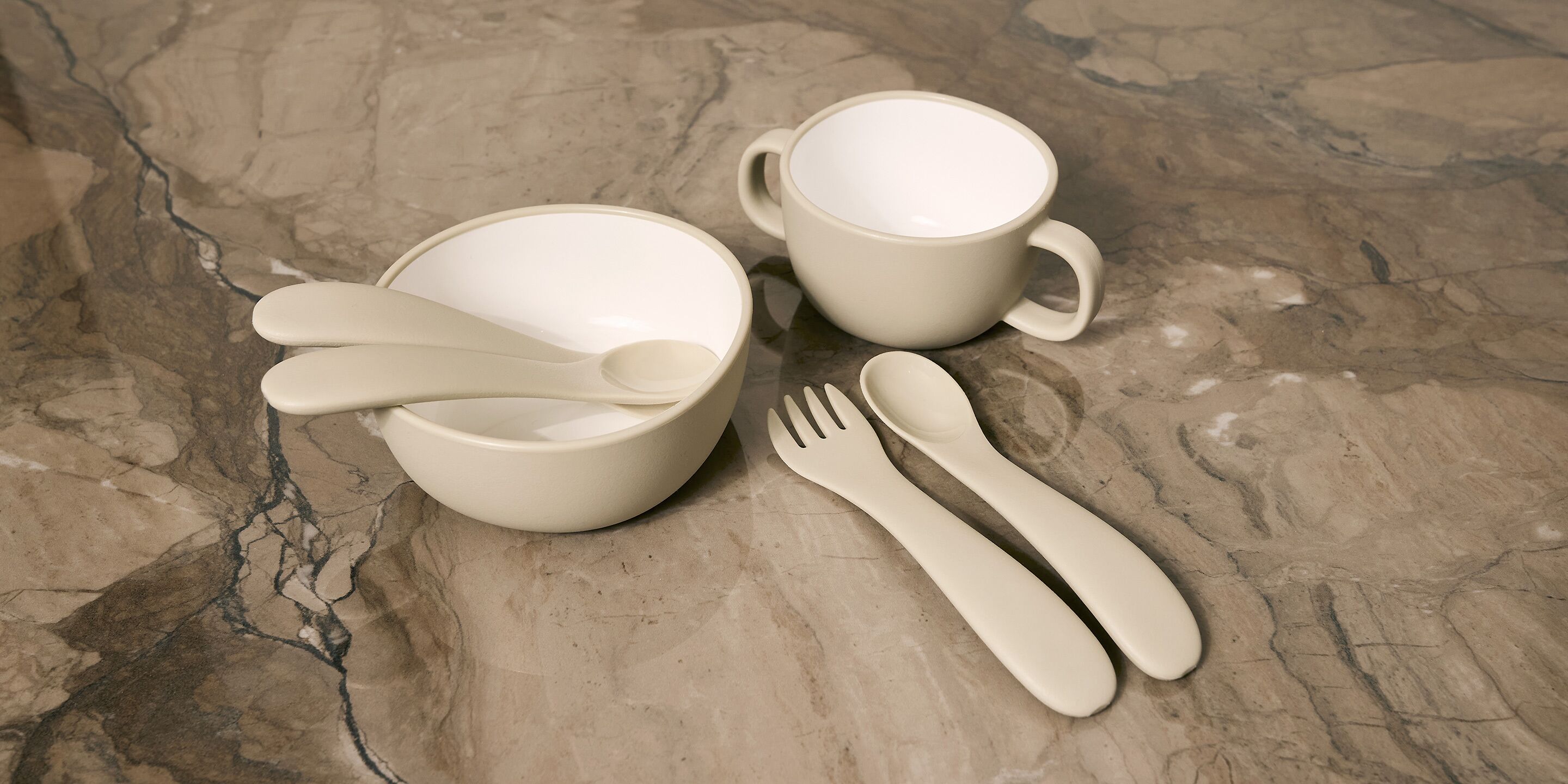 A set of white ceramic tableware on a marble surface.