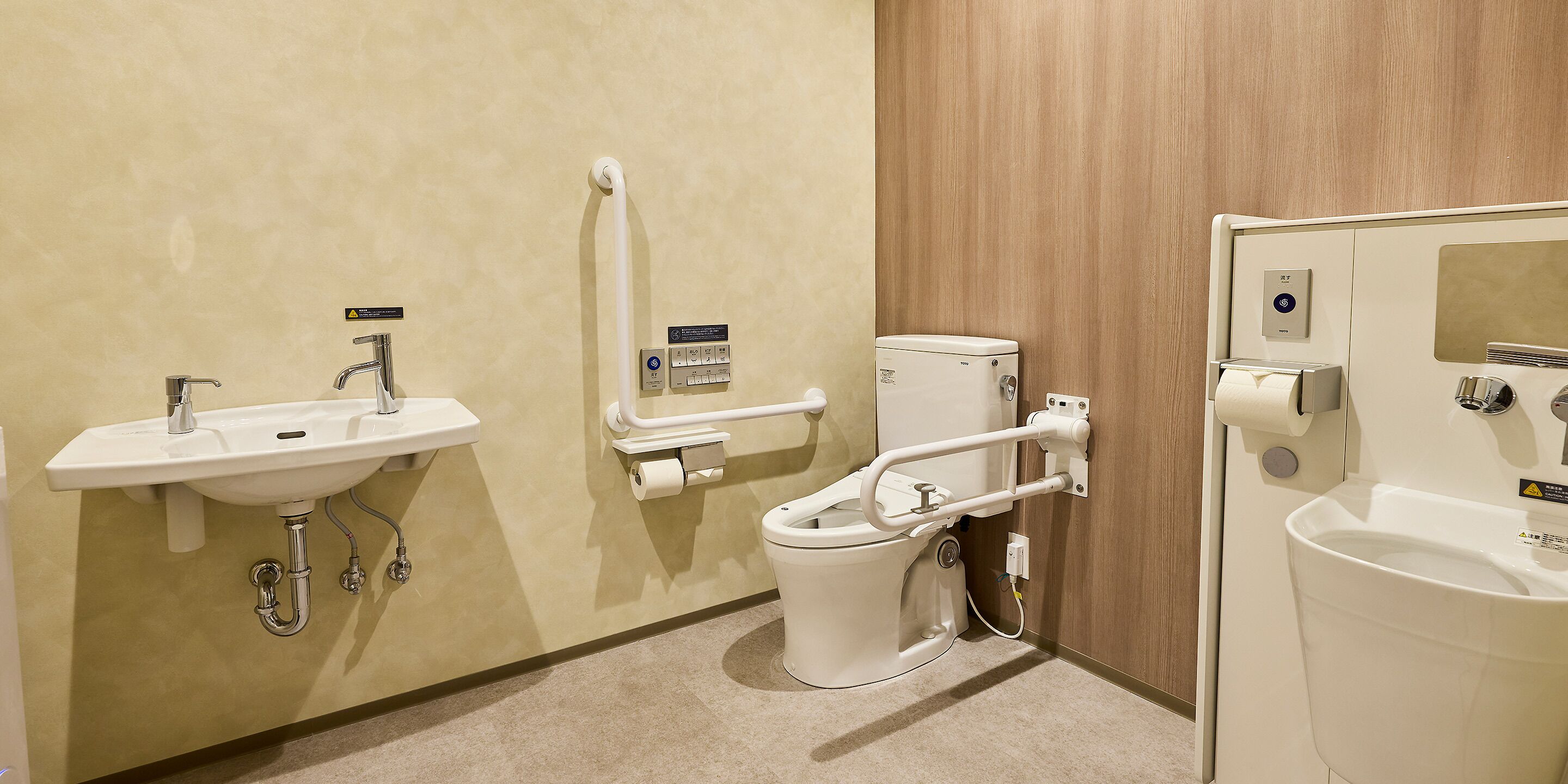 Une salle de bain équipée d’un lavabo, de toilettes et d’une barre d’appui.