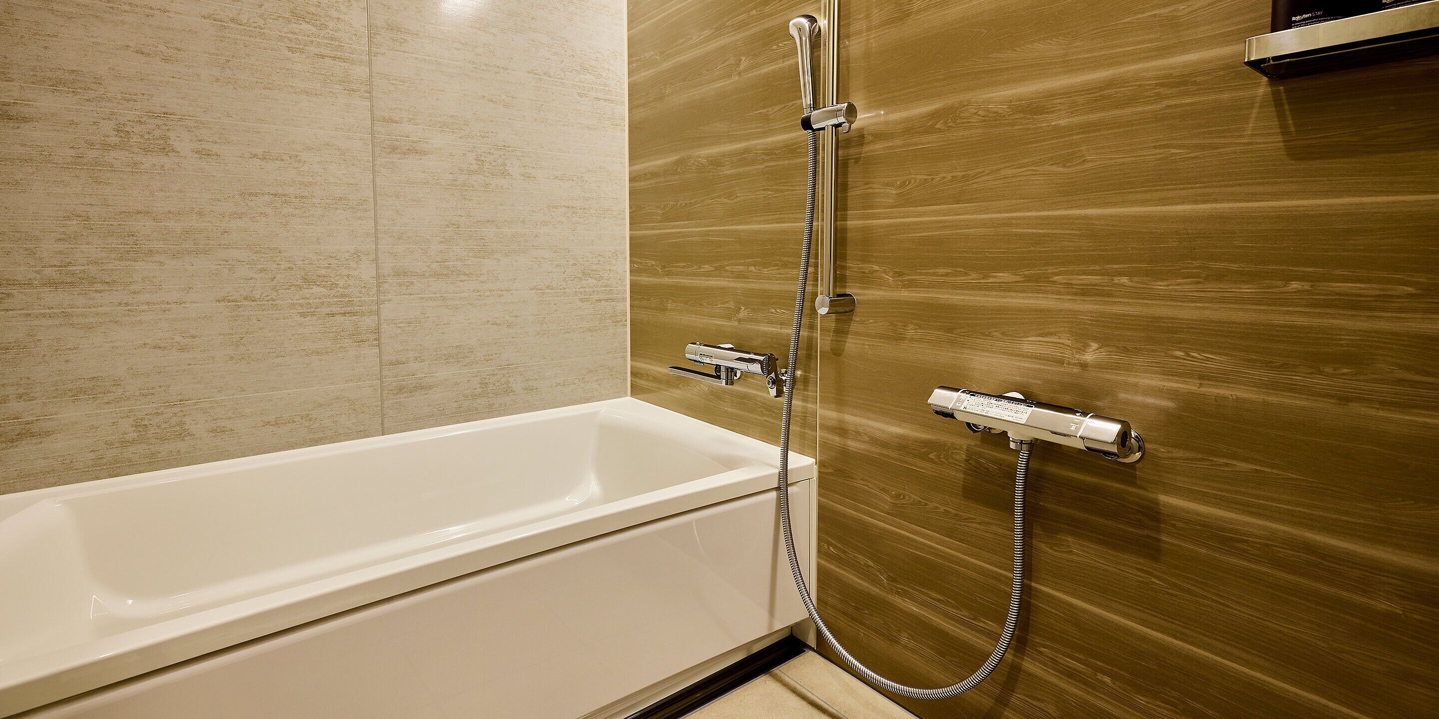 Un baño moderno con bañera, ducha y pared de madera.