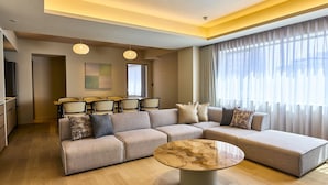 A modern living room with a sectional sofa, a round coffee table, and a dining area with chairs and a table. - Rakuten STAY Sapporo Nakajima Park (Sapporo)