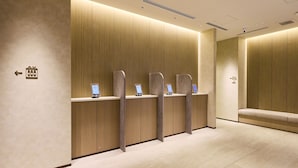 A hotel reception area with a wooden panel wall, a reception desk, and a seating area. - Rakuten STAY Sapporo Nakajima Park (Sapporo)
