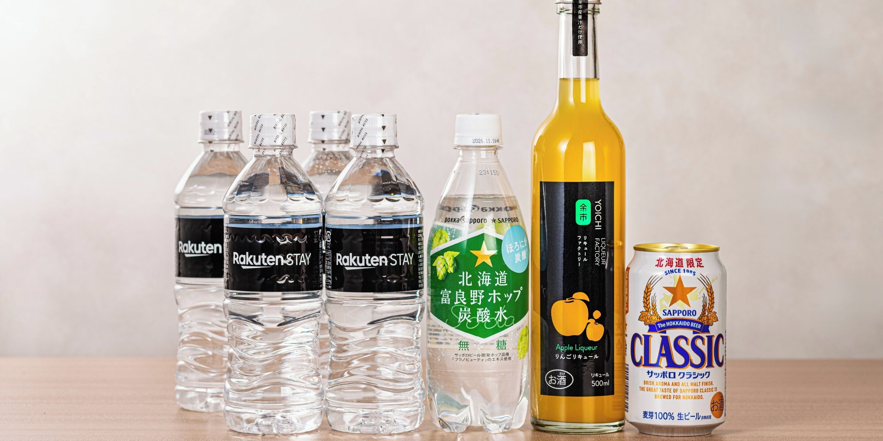 A variety of beverage bottles and a can on a table.
