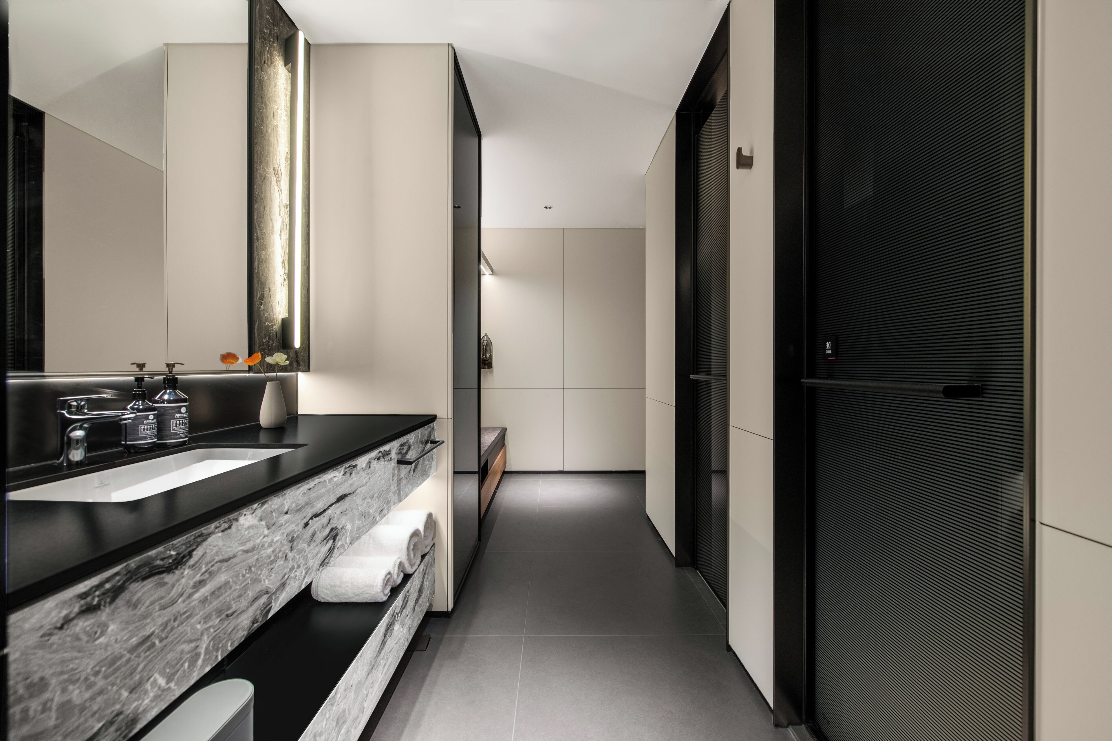 Un baño moderno con un espejo grande, dos lavamanos y una encimera de mármol.