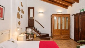 A hotel room with a bed, a wooden cabinet, a staircase, and a door marked 'SALIDA'. - Guestready - Hotel Rural Las Calas (Vega de San Mateo)