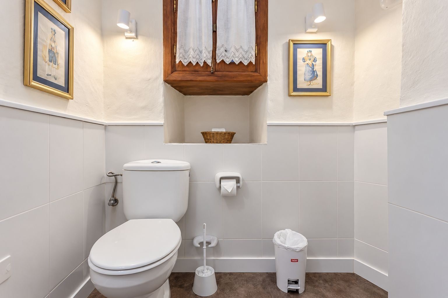 A bathroom with a toilet, bidet, and trash can.