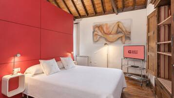 Un dormitorio moderno con una pared de acento roja, una cama grande, un cuadro y un cartel que dice 'GUEST READY'.