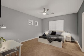 A bedroom with a bed, bedside tables, a desk, a ceiling fan, and a window with blinds. - Relaxing 5BR Tempe Home family pool moder home (Tempe)