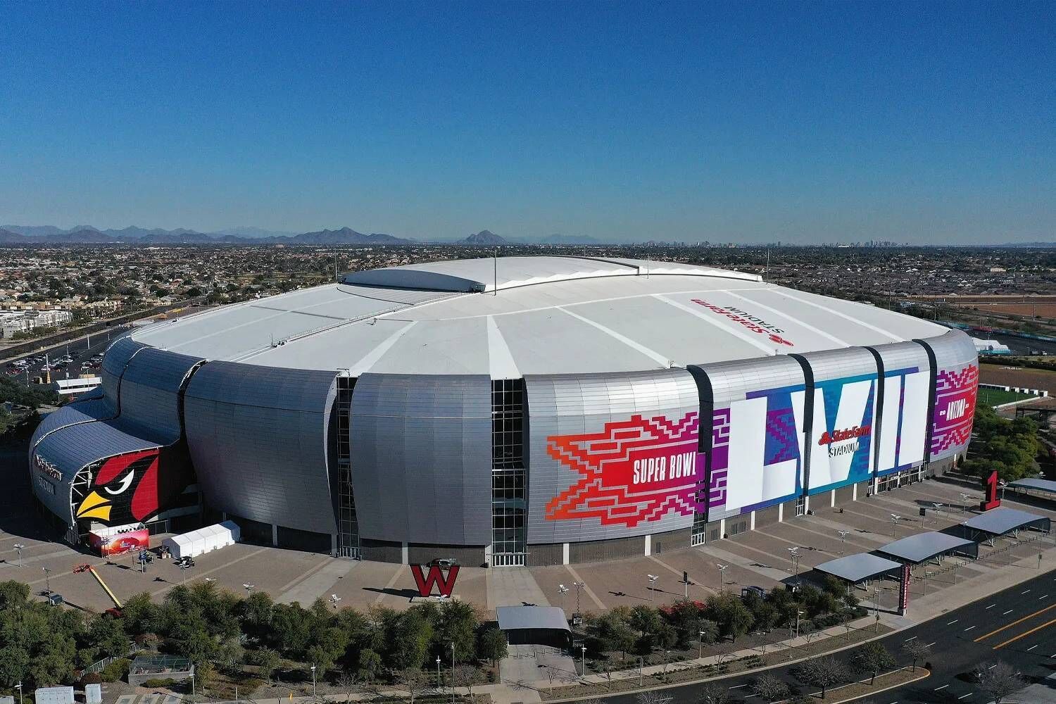 A large stadium with a distinctive curved roof and a prominent 'W' logo on the facade.