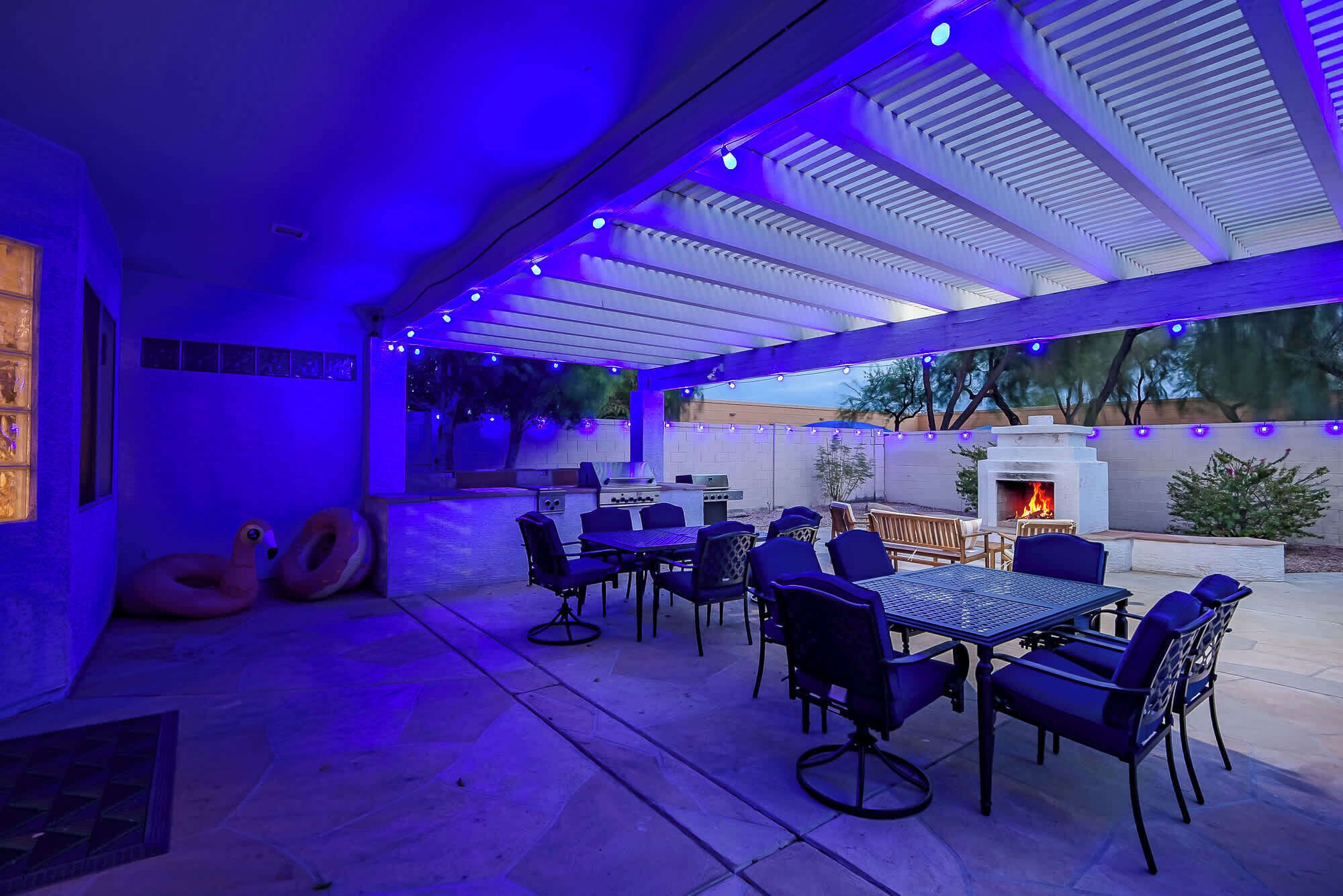 An outdoor patio with a grill, seating, and a fire feature.