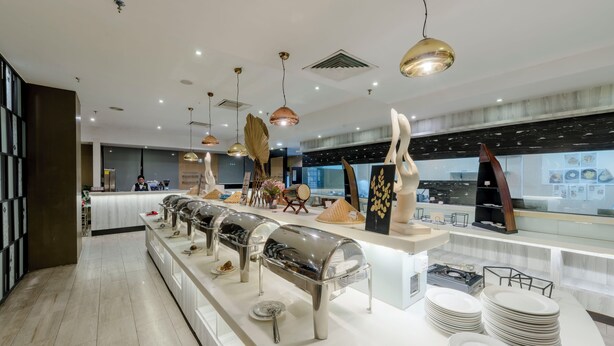 Un área de cocina moderna con electrodomésticos de acero inoxidable, un espacio tipo buffet y varios objetos decorativos.