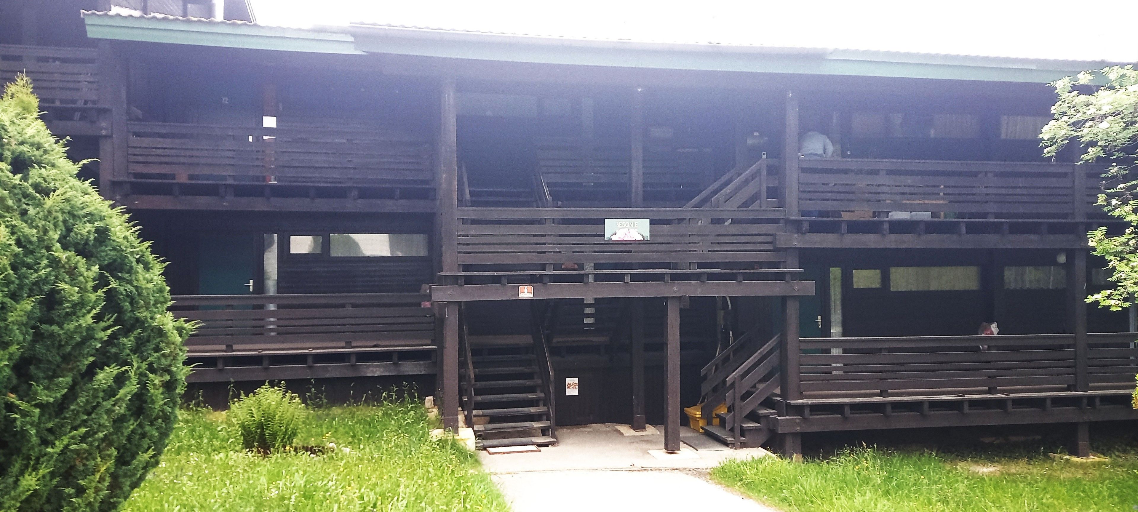 Een gebouw met twee verdiepingen en een hellingbaan naar de ingang.