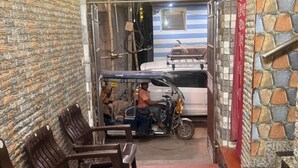 Una zona de estar con sillas, una mesita, un ventilador y una pared con textura.