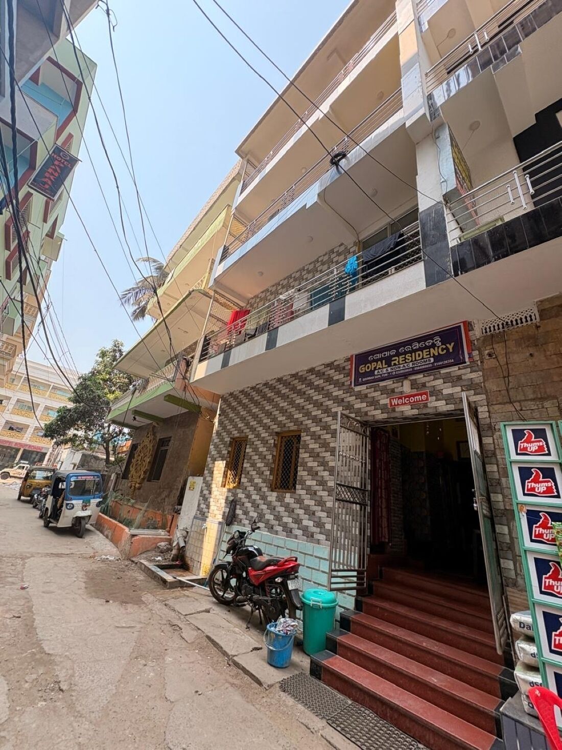 A building with a sign for 'Gopal Residency' indicating A/C & non-A/C rooms.
