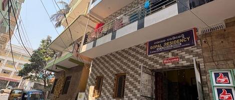 A building with a sign for 'Gopal Residency' indicating A/C & non-A/C rooms.