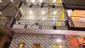 Un edificio de varios pisos con fachada de tejas, una escalera y un letrero que dice Gopal Residency.