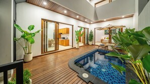 A modern indoor pool area with a wooden floor, a small pool, and potted plants. - Cassandra Villas - Your Bali Escape (Denpasar)