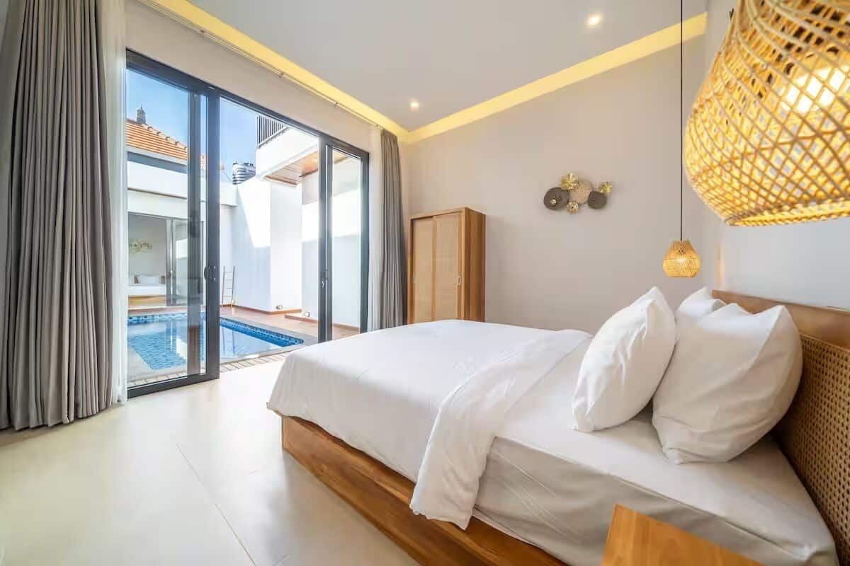Un dormitorio con cama, armario, vista a una piscina y una lámpara en el techo.